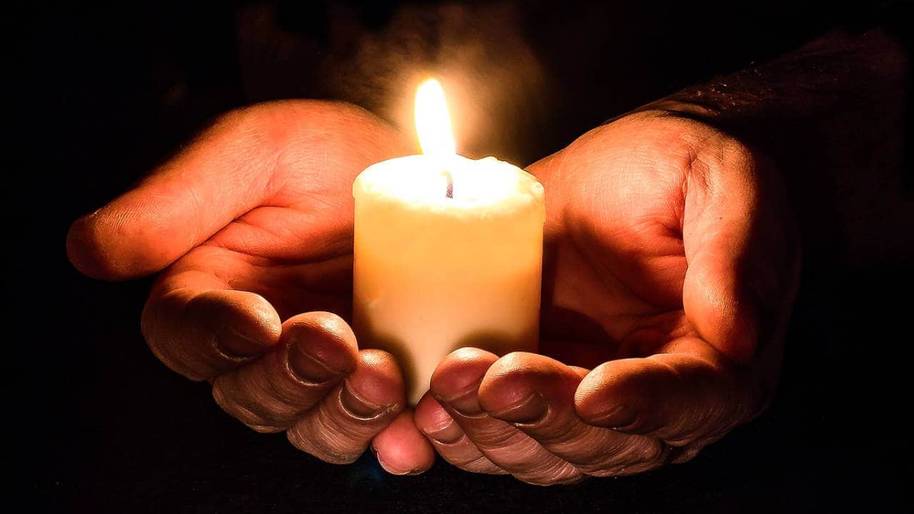 Manos con vela